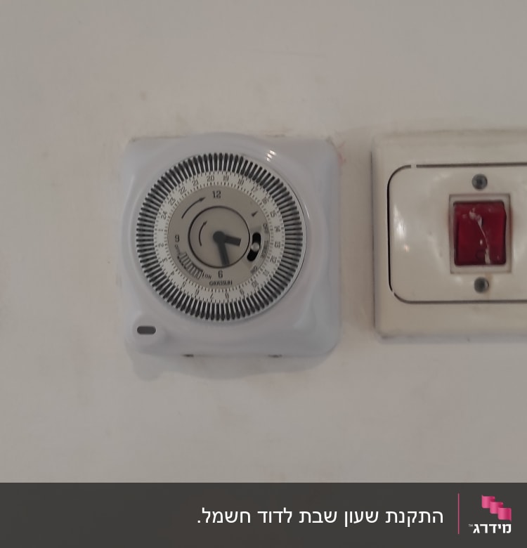 שעון טיימר חשמלי ומתג על קיר